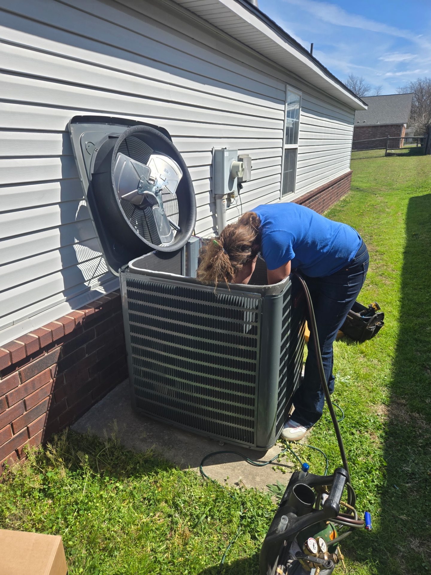 Kingdom Heat & Air technician servicing residential condenser unit